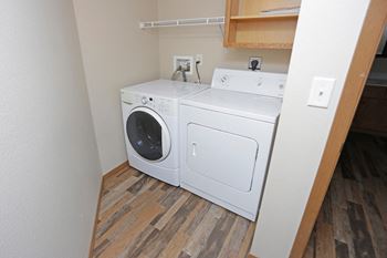 Washer and dryer beneath shelf in small closet room